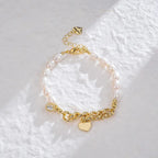Asymmetrical freshwater pearl gold link bracelet with dangling heart and crystal charms