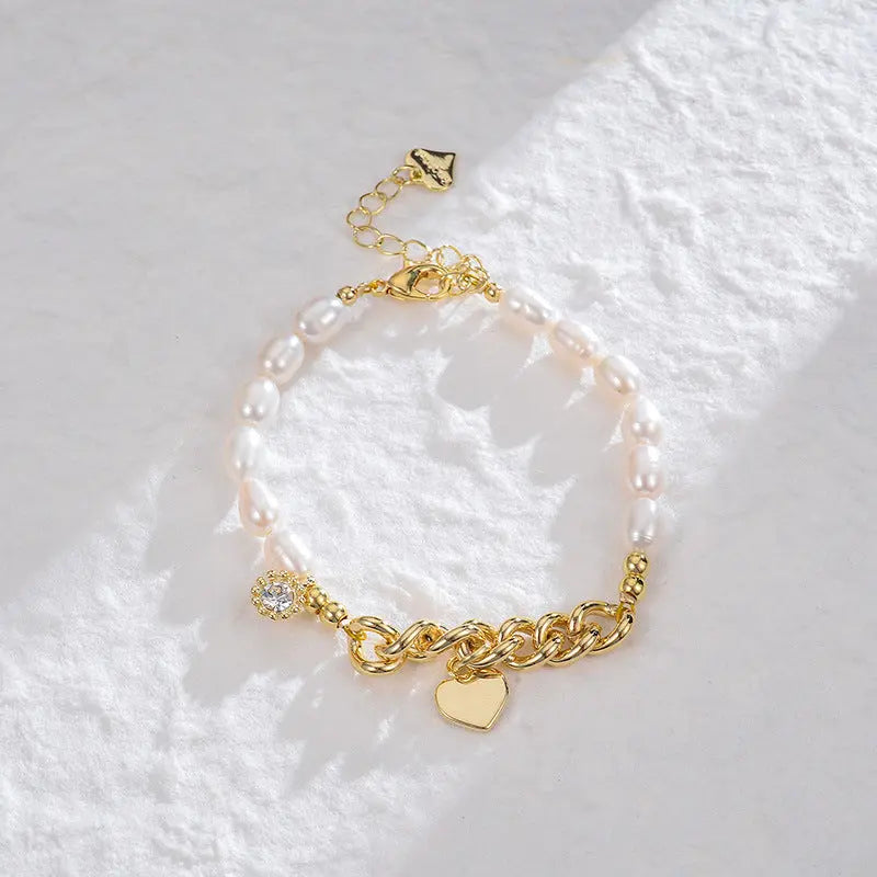 Asymmetrical freshwater pearl gold link bracelet with dangling heart and crystal charms