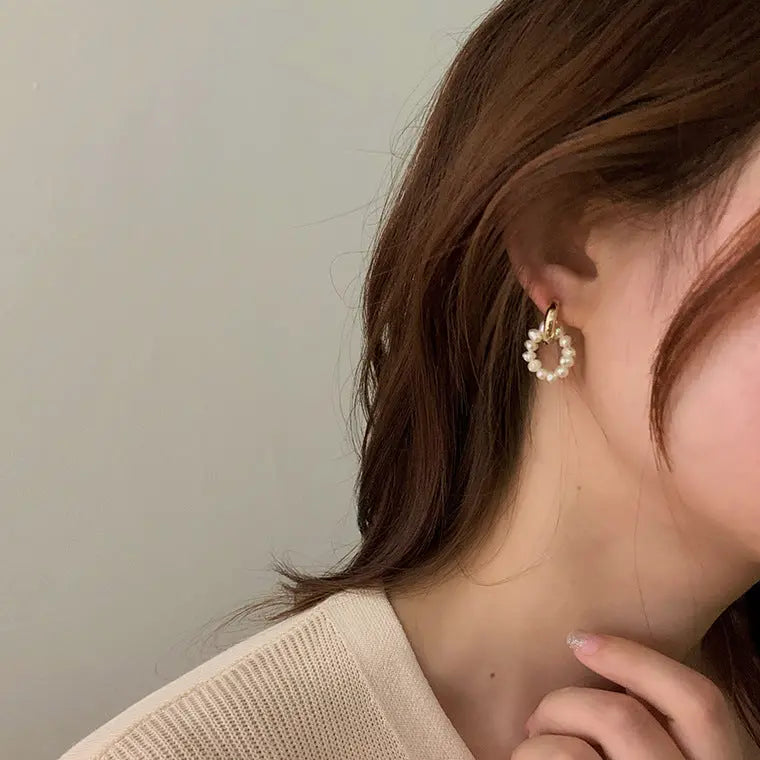 Model wearing natural freshwater pearl hoop earrings with gold French buckle
