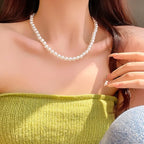 Classic single-strand faux pearl necklace on model in green top