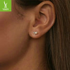 Close-up of a model wearing sparkling moissanite pearl cluster stud earrings