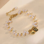 Natural freshwater pearl heart charm bracelet on a neutral beige background