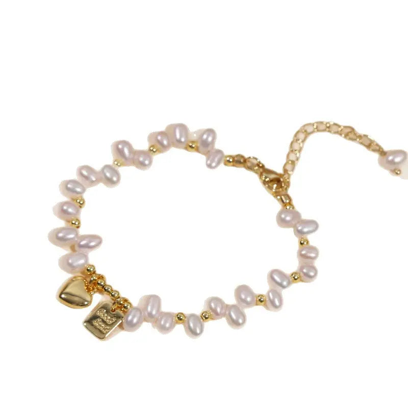 Dainty pearl charm bracelet with gold spacer beads on a clean white background