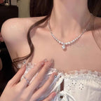 Silver-toned chain necklace with small pearls transitioning to a central pearl drop
