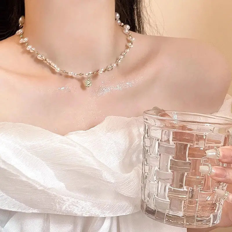 Gold-toned necklace with alternating pearls and gold beads featuring a ribbed circular pendant