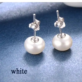 Classic minimalist white freshwater pearl stud earrings on a deep navy textured background