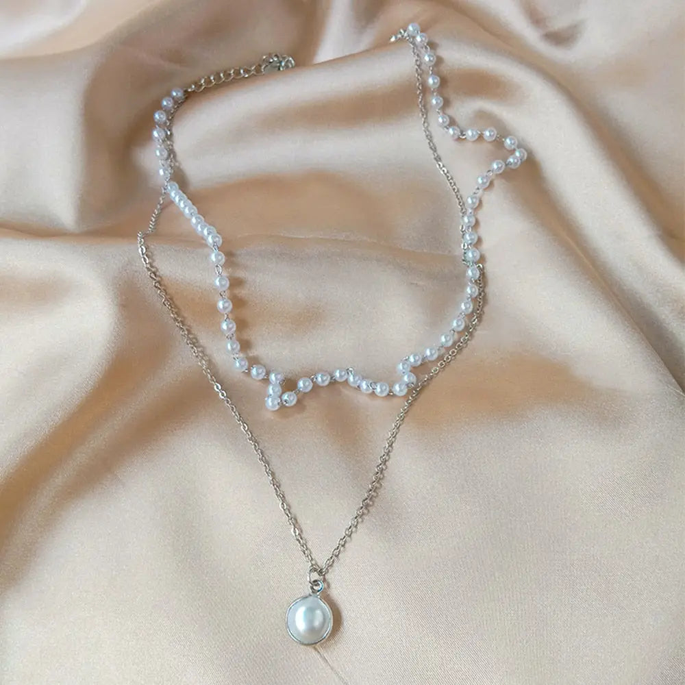 Silver double layer pearl necklace on champagne satin fabric