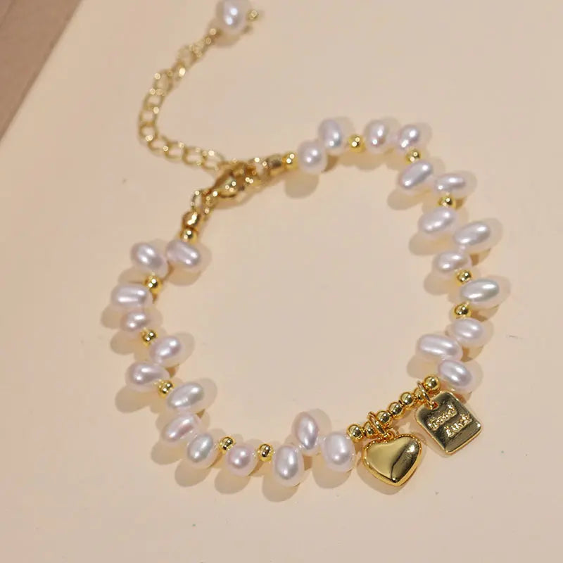 Double-strand freshwater pearl bracelet with a gold heart charm and tag