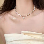Dainty white pearl choker interspersed with gold beads and a white camellia flower charm