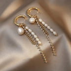 Gold bamboo hoop earrings with cascading freshwater pearls and rhinestone dangles on satin background
