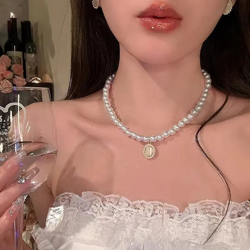 Dainty pearl choker with an opalescent cabochon stone pendant set in gold