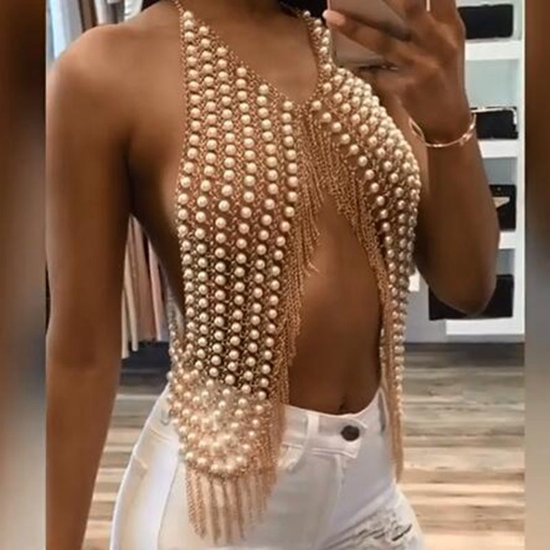 Simulated pearl body chain top with gold-toned chains worn over jeans