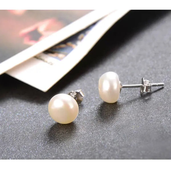 925 Sterling Silver white freshwater pearl stud earrings on a dark textured background