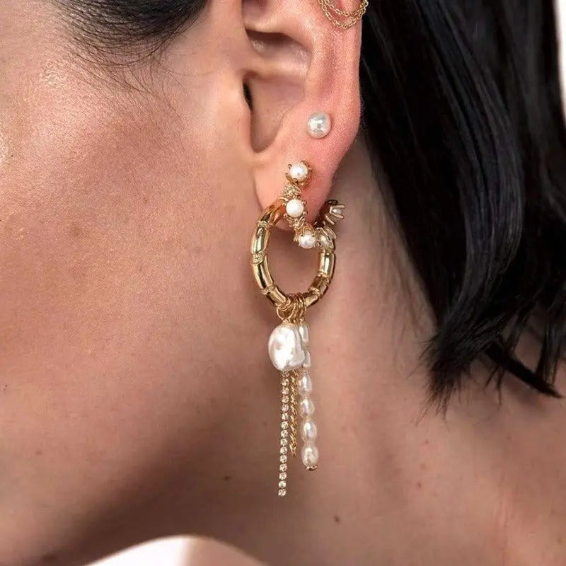 Model wearing gold bamboo textured statement hoop earring with dangling pearls and crystal fringe