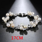 Detailed view of floral-themed pearl and cubic zirconia bracelet on a dark textured background