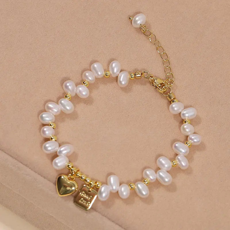 Handmade freshwater pearl bracelet with gold-tone accents and heart charm