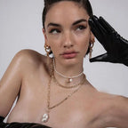 Editorial model styled with layered gold necklaces and gold bamboo-textured hoop earrings