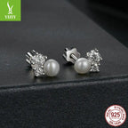 Sparkling moissanite and freshwater pearl cluster stud earrings on matte black background