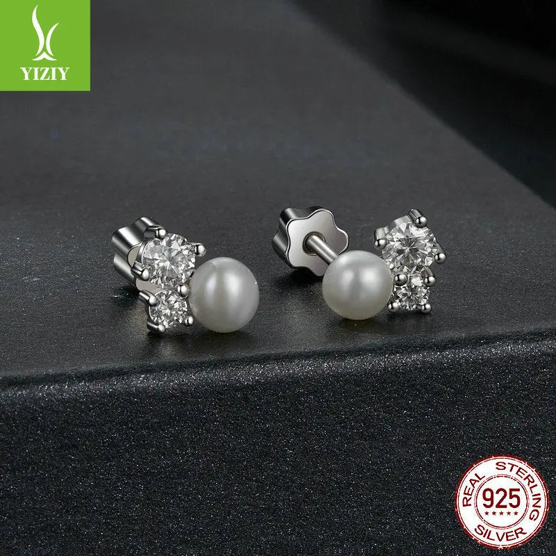 Sparkling moissanite and freshwater pearl cluster stud earrings on matte black background