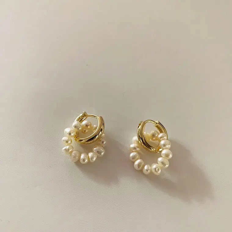 Double loop design natural freshwater pearl dangle earrings on off-white background
