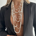 Close-up of Pearl Layered Statement Body Chain in white pearls and gold chains on a black blazer
