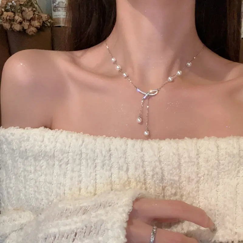 Lariat-style pearl necklace with a sparkling crystal bow knot on silver chain