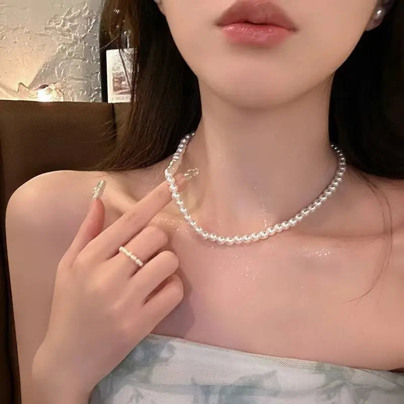 Close-up of a classic high-gloss white pearl choker necklace and matching ring