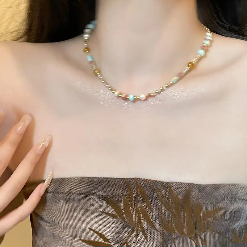 Beaded choker necklace with mixed colorful gemstones, pearls, and gold-tone beads