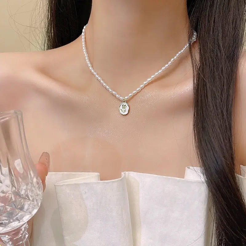 Semi-baroque freshwater pearl choker with an enamel rose-motif pendant