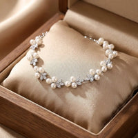 Elegant floral freshwater pearl bracelet on a seamless white background, flat lay studio shot
