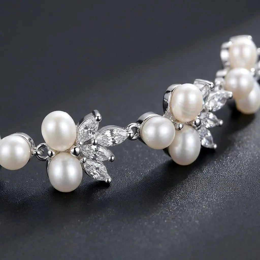 Dainty pearl and cubic zirconia floral bracelet displayed on beige silk cushion in a luxury jewelry box