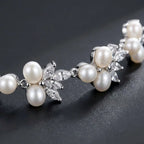 Dainty pearl and cubic zirconia floral bracelet displayed on beige silk cushion in a luxury jewelry box