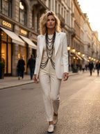 Lifestyle shot of a model wearing the black Pearl Layered Statement Body Chain over a tailored cream-white blazer
