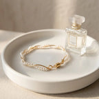 Elegant product display of the gold wave adjustable freshwater pearl bracelet on a white ceramic jewelry dish
