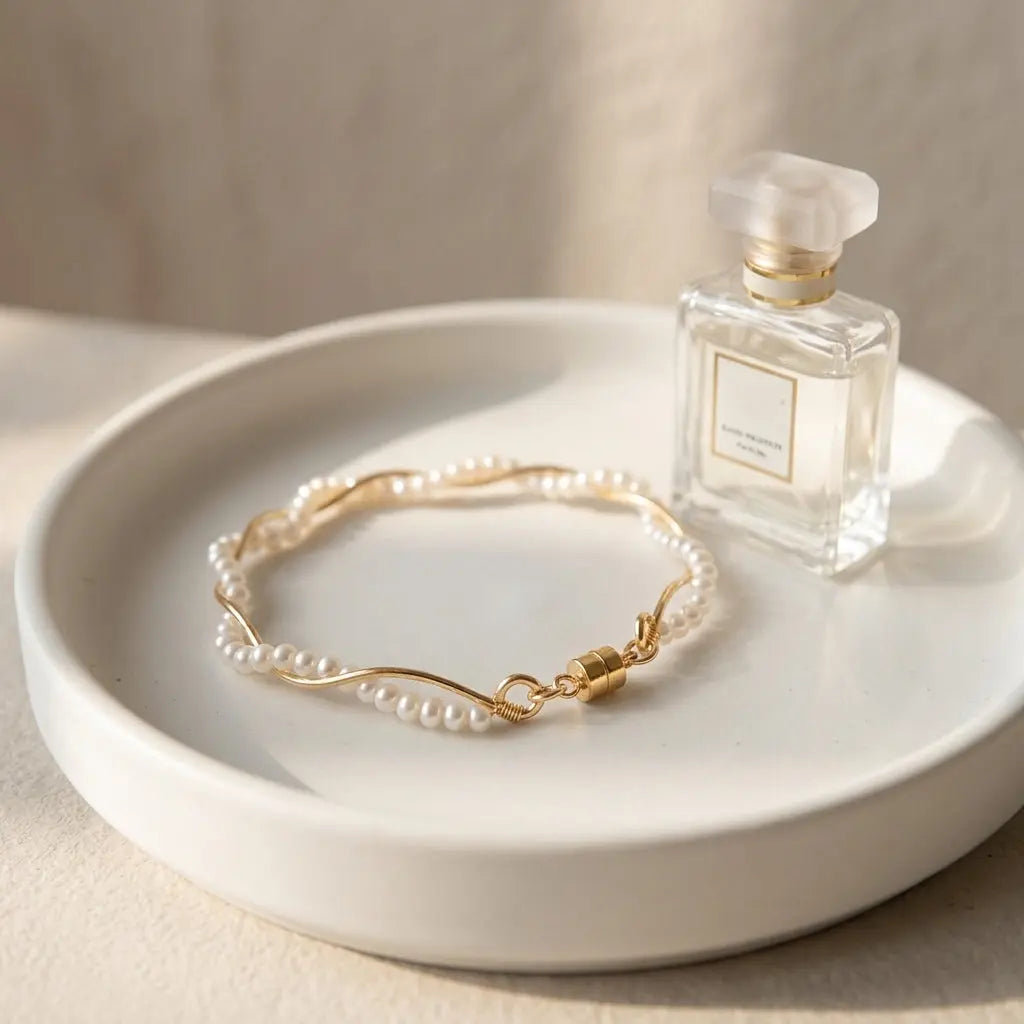 Elegant product display of the gold wave adjustable freshwater pearl bracelet on a white ceramic jewelry dish
