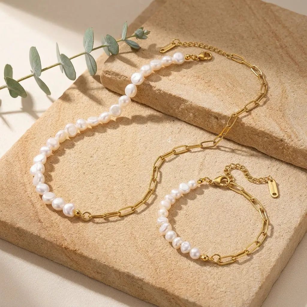 Asymmetrical half pearl half chain necklace on sandstone slab with eucalyptus accent