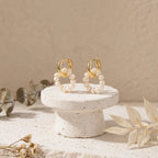 Natural freshwater pearl hoop earrings displayed on a white stone pedestal minimalist lifestyle setup