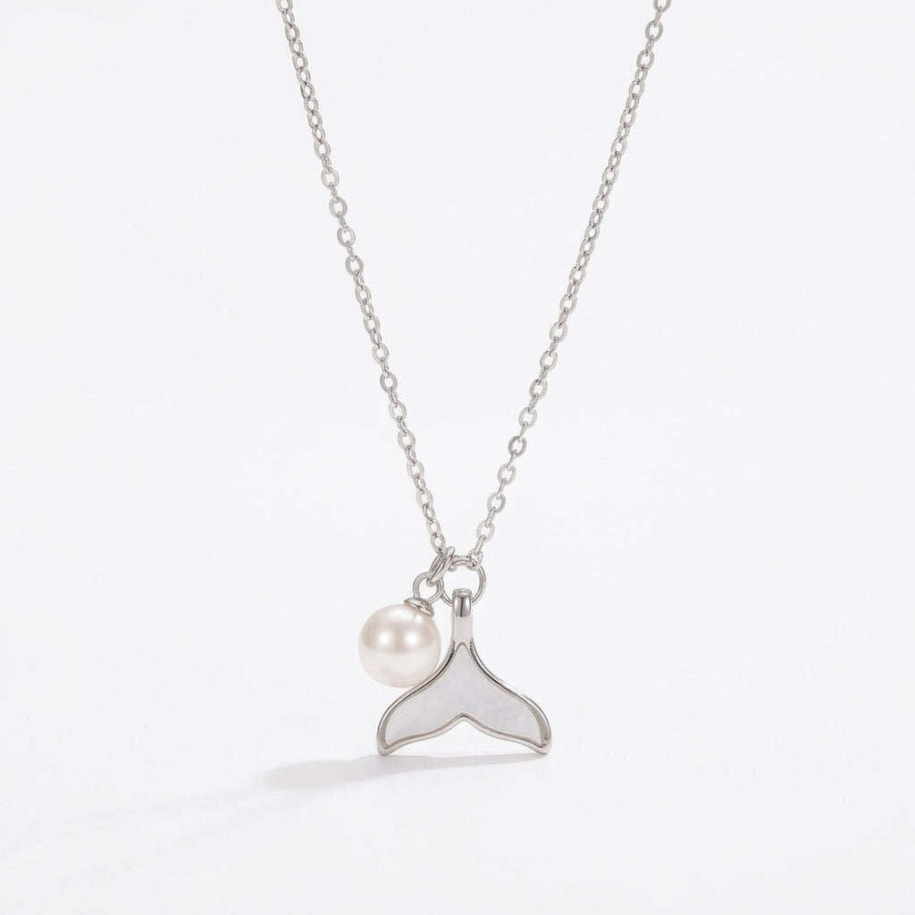 Silver Fishtail Pearl Pendant Necklace on a white pearlescent shell plate, bright elegant morning light aesthetic