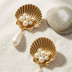 Gold Scallop Shell Pearl Drop Earrings on white sand beach setting